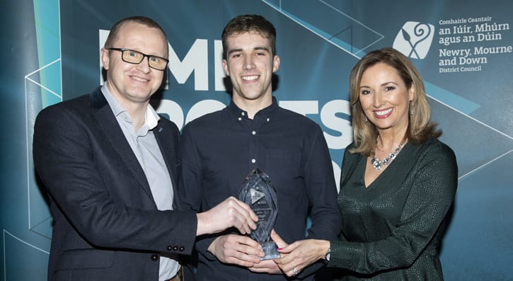 Neil McCracken, Phoenix Natural Gas presents the Young Sport Volunteer of the Year 2019 award to Niall Flynn, Loughinisland Gaelic Football Club. The award category was sponsored by Phoenix Natural Gas. Included is awards host Claire McCollum. 